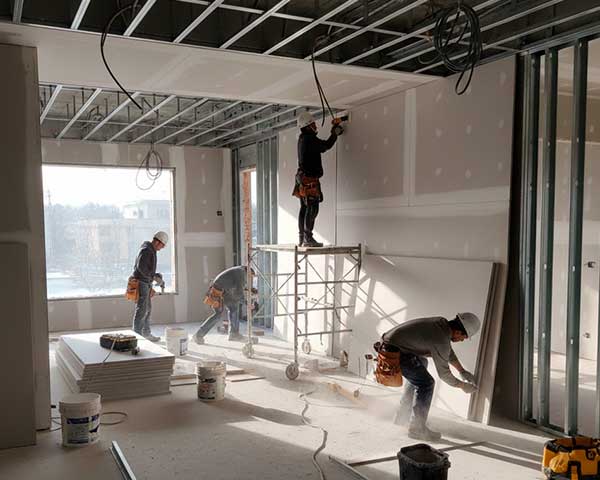 homens montando parede e teto com chapas de gesso